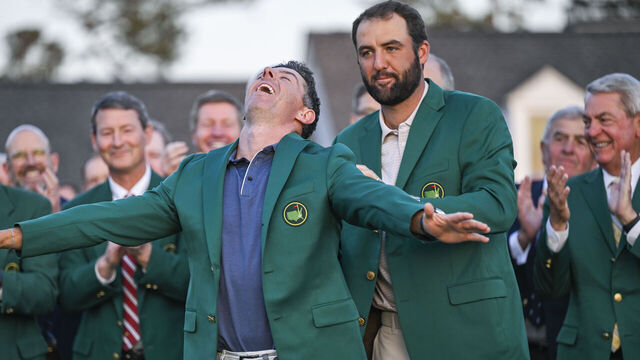 AUGUSTA, GEORGIA - APRIL 13: Rory McIlroy of Northern Ireland smiles during the Green Jacket and trophy presentation ceremony with Scottie Scheffler following his playoff victory in the final round of the Masters Tournament at Augusta National Golf Club on April 13, 2025 in Augusta, Georgia.