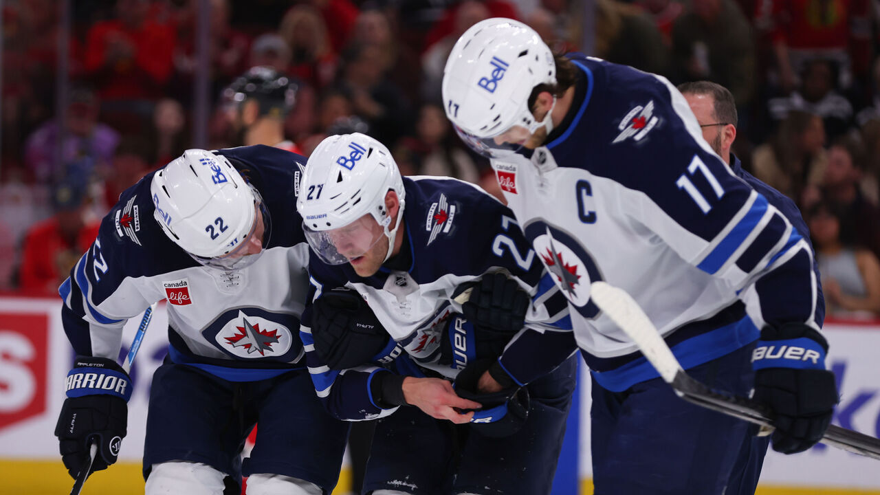 CHICAGO, IL - APRIL 12: Mason Appleton #22 of the Winnipeg Jets helps Nikolaj Ehlers #27 of the Winnipeg Jets to the bench during the second period against the Chicago Blackhawks on April 12. 2025 at the United Center in Chicago, Illinois.