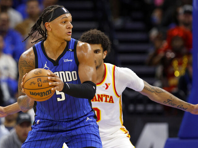ORLANDO, FLORIDA - APRIL 15: Paolo Banchero #5 of the Orlando Magic posts up Zaccharie Risacher #10 of the Atlanta Hawks during the first half of an NBA play-in tournament game at Kia Center on April 15, 2025 in Orlando, Florida.