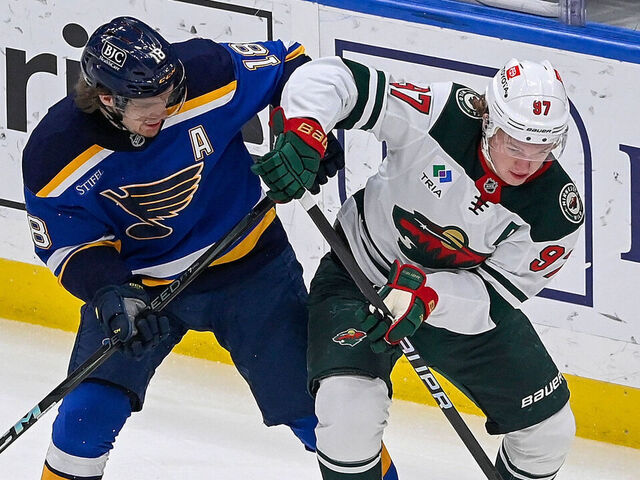ST. LOUIS, MO - NOVEMBER 19: Robert Thomas #18 of the St. Louis Blues and Kirill Kaprizov #97 of the Minnesota Wild battle for the puck on November 19, 2024 at the Enterprise Center in St. Louis, Missouri.