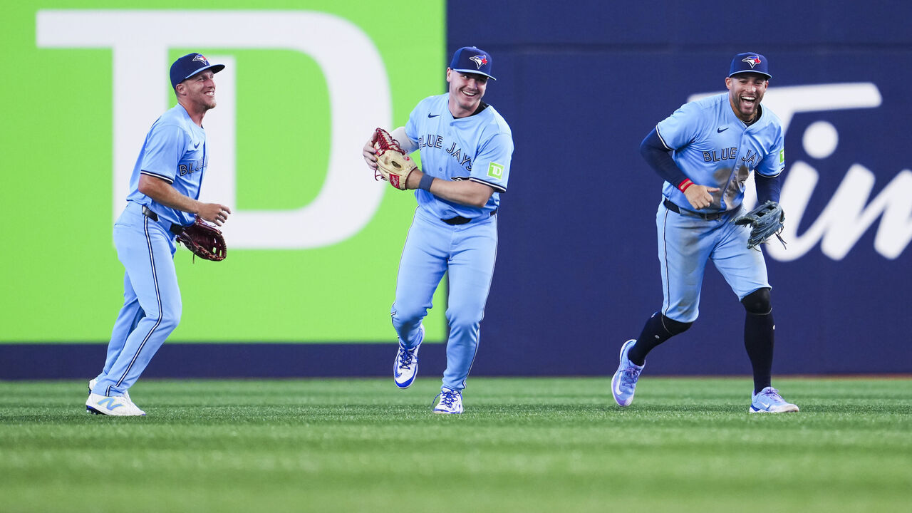 TORONTO, ON - MARCH 31: George Springer, Myles Straw #3, and Alan Roden #18 of Toronto Blue Jays celebrate defeating the Washington Nationals in their MLB game at the Rogers Centre on March 31, 2025 in Toronto, Ontario, Canada.