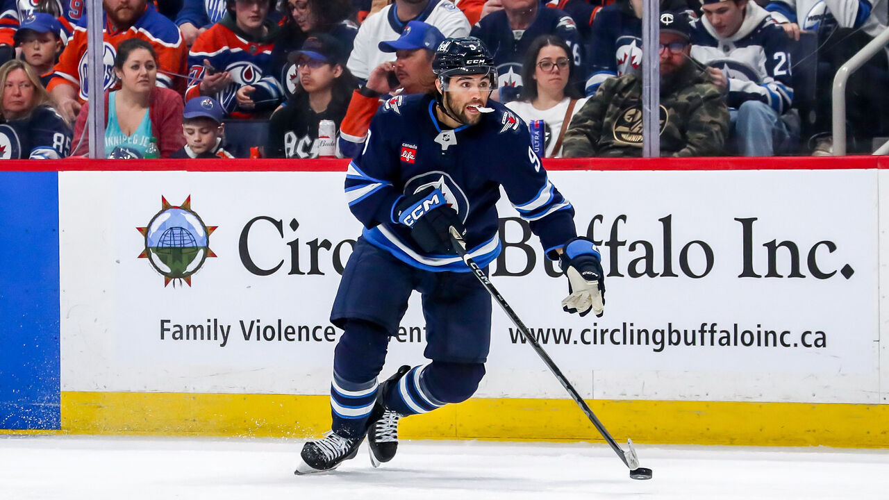 WINNIPEG, CANADA - APRIL 13: Alex Iafallo #9 of the Winnipeg Jets plays the puck down the ice during third period action against the Edmonton Oilers at the Canada Life Centre on April 13, 2025 in Winnipeg, Manitoba, Canada. The Oilers defeated the Jets 4-1.