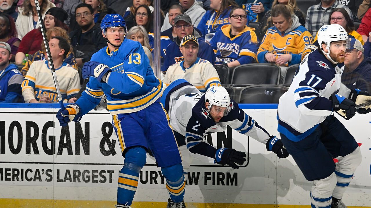 ST. LOUIS, MO - FEBRUARY 22: Alexey Toropchenko #13 of the St. Louis Blues checks Dylan DeMelo #2 of the Winnipeg Jets on February 22, 2025 at the Enterprise Center in St. Louis, Missouri.