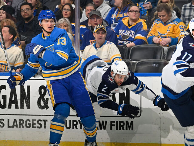 ST. LOUIS, MO - FEBRUARY 22: Alexey Toropchenko #13 of the St. Louis Blues checks Dylan DeMelo #2 of the Winnipeg Jets on February 22, 2025 at the Enterprise Center in St. Louis, Missouri.