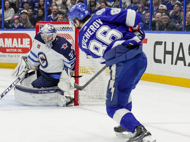 TAMPA, FL - MARCH 12: Tampa Bay Lightning right wing Nikita Kucherov (86) shoots and hits Winnipeg Jets goaltender Connor Hellebuyck (37) in the Winnipeg Jets chest logo during the NHL Hockey match between the Tampa Bay Lightning and Winnipeg Jets on March 12th, 2023 at Amalie Arena in Tampa, FL.