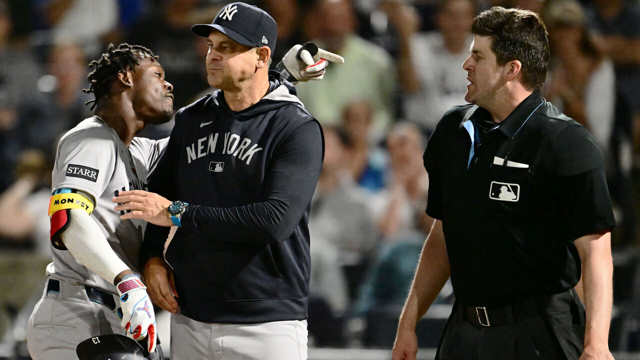 TAMPA, FLORIDA - APRIL 17: Jazz Chisholm Jr. #13 of the New York Yankees is held back by manager Aaron Boone #17 after an ejection by umpire John Bacon #70 in the seventh inning against the Tampa Bay Rays at George M. Steinbrenner Field on April 17, 2025 in Tampa, Florida.