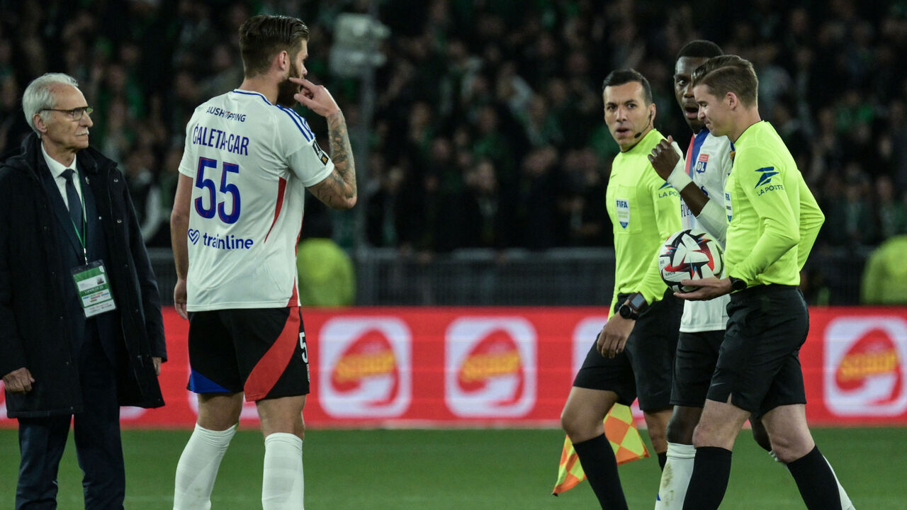 French referee Mehdi Rahmoun (3rd R) looks on during the French L1 football match between AS Saint-Etienne and Olympique Lyonnais (OL) after the match was suspended at the Geoffroy-Guichard Stadium in Saint-Etienne, central France on April 20, 2025. The derby between Saint-Etienne and Lyon was interrupted on Sunday evening just before half-time (45th) after a projectile thrown from the stands hit touchline referee Mehdi Rahmouni on the head. Lyon fans have been banned from travelling to this derby, which has often been marked by incidents.