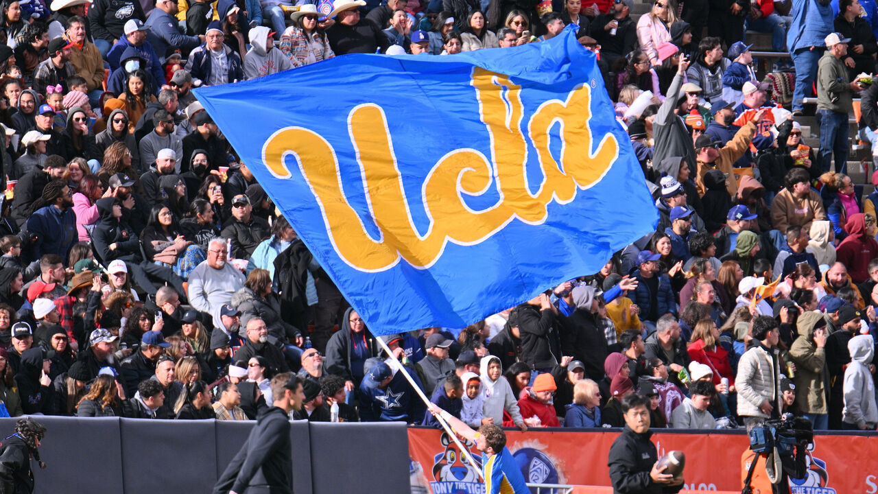 EL PASO, TEXAS - DECEMBER 30: A UCLA Bruins cheerleader waves a UCLA flag during the second half of the Tony the Tiger Sun Bowl game between the Pittsburgh Panthers and the Bruins at Sun Bowl Stadium on December 30, 2022 in El Paso, Texas. The Panthers defeated the Bruins 37-35.