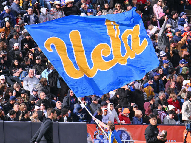 EL PASO, TEXAS - DECEMBER 30: A UCLA Bruins cheerleader waves a UCLA flag during the second half of the Tony the Tiger Sun Bowl game between the Pittsburgh Panthers and the Bruins at Sun Bowl Stadium on December 30, 2022 in El Paso, Texas. The Panthers defeated the Bruins 37-35.