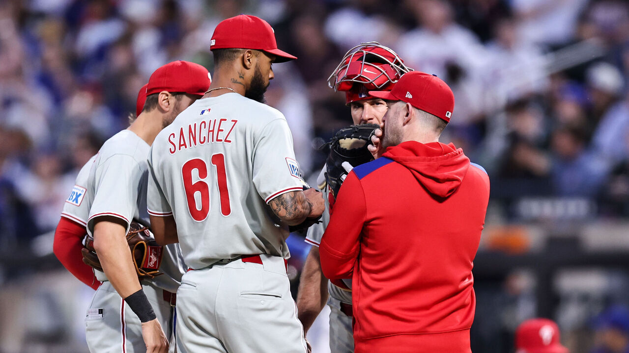 NEW YORK, NEW YORK - APRIL 22: Cristopher Sánchez #61 of the Philadelphia Phillies with pitching coach Caleb Cotham during a mound visit in the bottom of the first inning of the game against the New York Mets at Citi Field on April 22, 2025 in the Flushing neighborhood of the Queens borough of New York City.