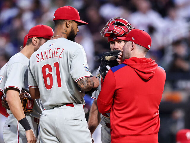 NEW YORK, NEW YORK - APRIL 22: Cristopher Sánchez #61 of the Philadelphia Phillies with pitching coach Caleb Cotham during a mound visit in the bottom of the first inning of the game against the New York Mets at Citi Field on April 22, 2025 in the Flushing neighborhood of the Queens borough of New York City.