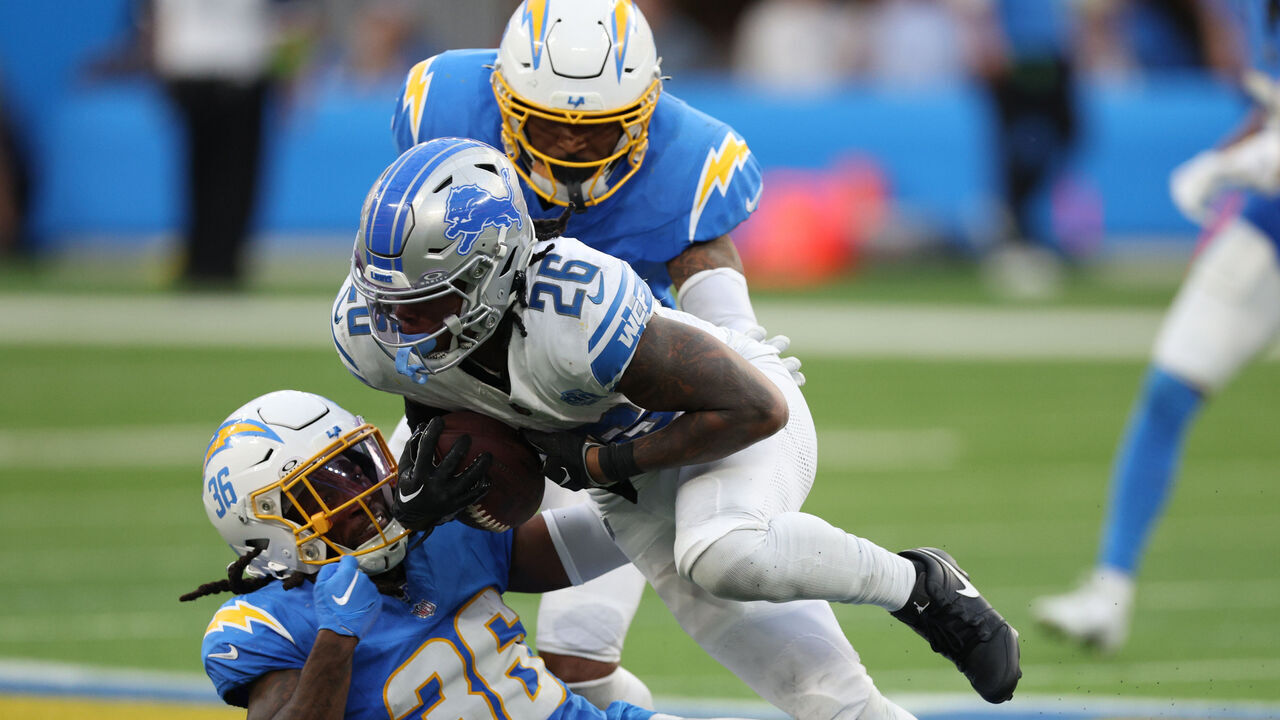 INGLEWOOD, CALIFORNIA - NOVEMBER 12: Jahmyr Gibbs #26 of the Detroit Lions runs with the ball against Ja'Sir Taylor #36 and Derwin James Jr. #3 of the Los Angeles Chargers during a 41-38 Lions win at SoFi Stadium on November 12, 2023 in Inglewood, California.