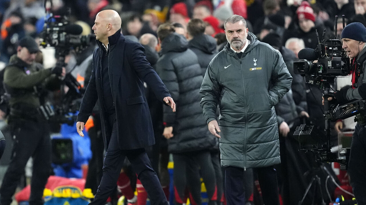Tottenham Hotspur manager Ange Postecoglou (right) looks dejected after the final whistle as Liverpool manager Arne Slot walks away in the Carabao Cup Semi-Final, second leg match at Anfield, Liverpool. Picture date: Thursday February 6, 2025.