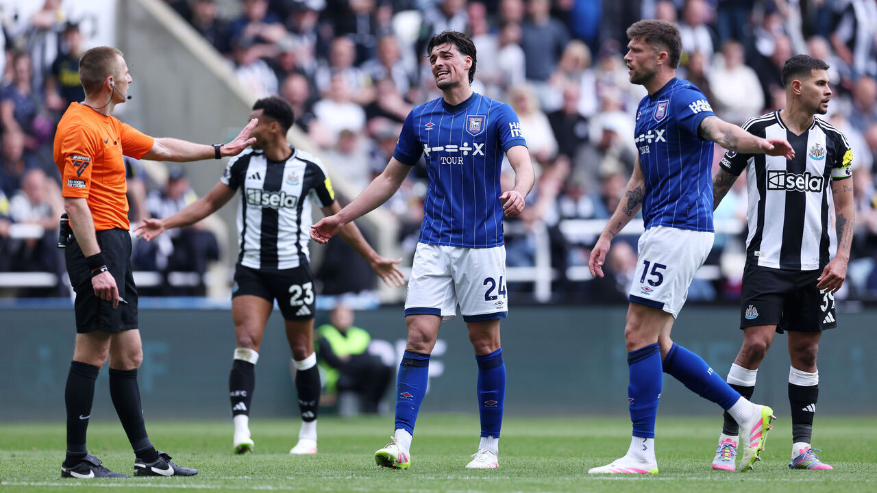 NEWCASTLE UPON TYNE, ENGLAND - APRIL 26: Jacob Greaves and Cameron Burgess of Ipswich Town confront match referee Michael Salisbury after a penalty is awarded during the Premier League match between Newcastle United FC and Ipswich Town FC at St James' Park on April 26, 2025 in Newcastle upon Tyne, England.