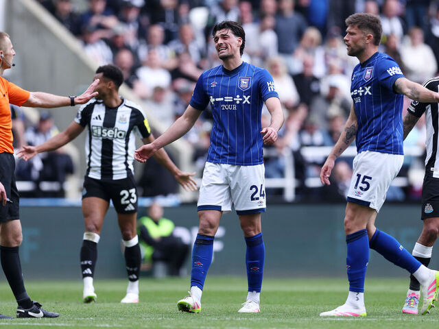 NEWCASTLE UPON TYNE, ENGLAND - APRIL 26: Jacob Greaves and Cameron Burgess of Ipswich Town confront match referee Michael Salisbury after a penalty is awarded during the Premier League match between Newcastle United FC and Ipswich Town FC at St James' Park on April 26, 2025 in Newcastle upon Tyne, England.