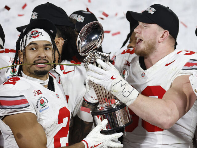 PASADENA, CALIFORNIA - JANUARY 01: Emeka Egbuka #2 and Jack Sawyer #33 of the Ohio State Buckeyes hold the Leishman Trophy after defeating the Oregon Ducks 41-21 during the Rose Bowl Game Presented by Prudential at Rose Bowl Stadium on January 01, 2025 in Pasadena, California.