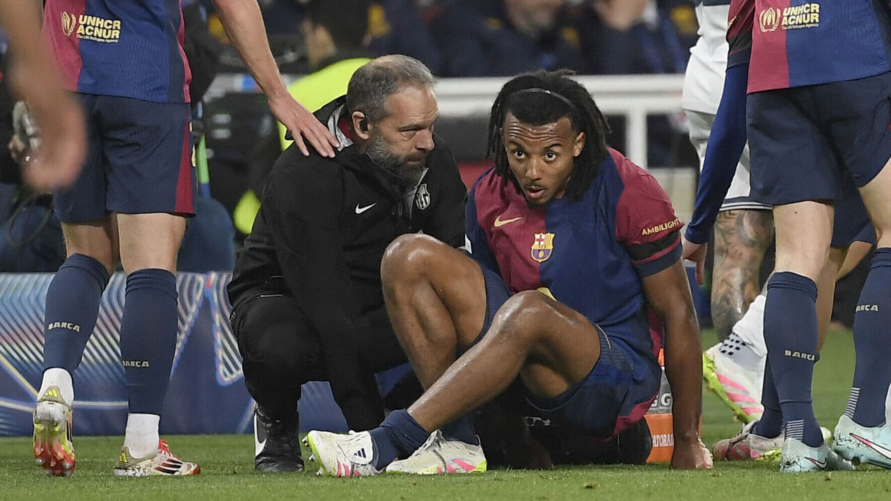 Medical staff's member tends to Barcelona's French defender #23 Jules Kounde during the UEFA Champions League semi final first leg football match between FC Barcelona and Inter Milan at the Estadi Olimpic Lluis Companys in Barcelona on April 30, 2025.