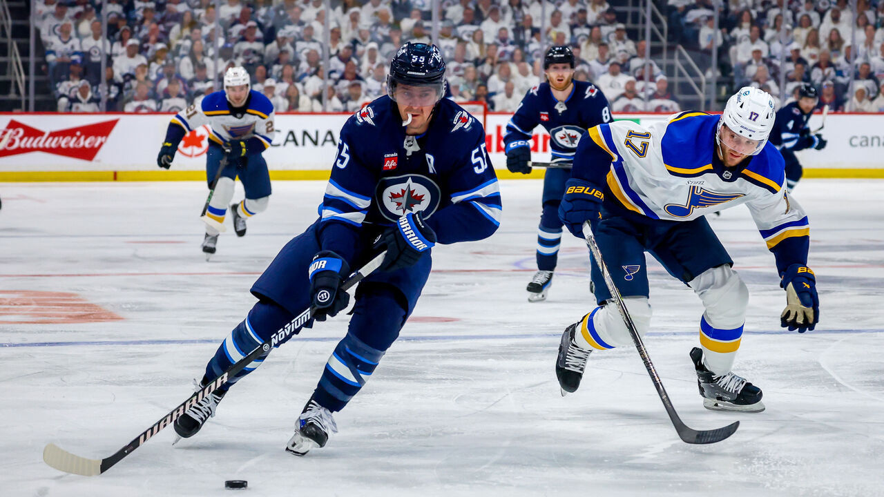 WINNIPEG, CANADA - APRIL 21: Mark Scheifele #55 of the Winnipeg Jets plays the puck away from Cam Fowler #17 of the St. Louis Blues during second period action in Game Two of the First Round of the 2025 Stanley Cup Playoffs at Canada Life Centre on April 21, 2025 in Winnipeg, Manitoba, Canada.