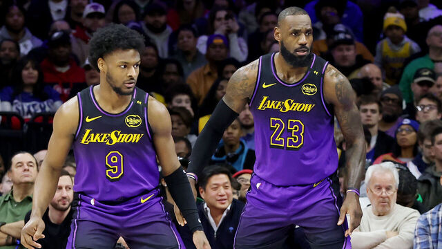 PHILADELPHIA, PENNSYLVANIA - JANUARY 28: Bronny James #9 stands by LeBron James #23 of the Los Angeles Lakers during the second half against the Philadelphia 76ers at the Wells Fargo Center on January 28, 2025 in Philadelphia, Pennsylvania.