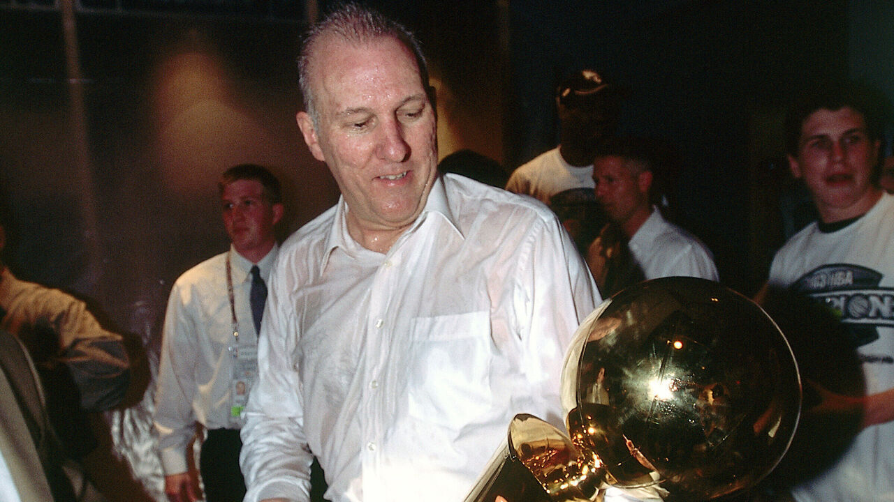 SAN ANTONIO - JUNE 15: Head Coach Greg Popovich of the San Antonio Spurs holds and admires the NBA Championship Trophy after winning Game six of the 2003 NBA Finals to take the championship on June 15, 2003 at the SBC Center in San Antonio, Texas. Mandatory copyright notice: Copyright NBAE 2003