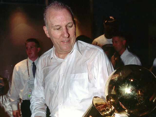 SAN ANTONIO - JUNE 15: Head Coach Greg Popovich of the San Antonio Spurs holds and admires the NBA Championship Trophy after winning Game six of the 2003 NBA Finals to take the championship on June 15, 2003 at the SBC Center in San Antonio, Texas. Mandatory copyright notice: Copyright NBAE 2003