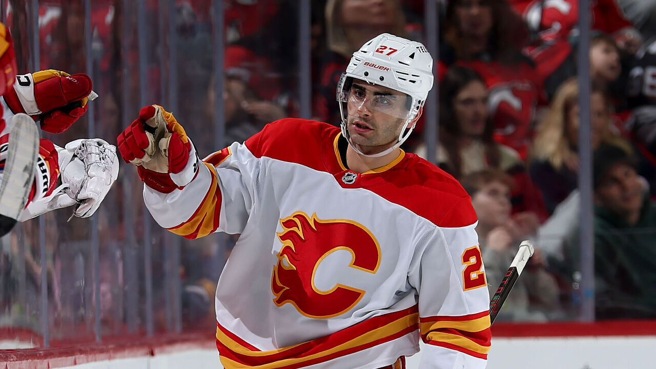 NEWARK, NEW JERSEY - MARCH 20: Matt Coronato #27 of the Calgary Flames celebrates his goal with teammates on the bench during the second period against the New Jersey Devils at Prudential Center on March 20, 2025 in Newark, New Jersey.