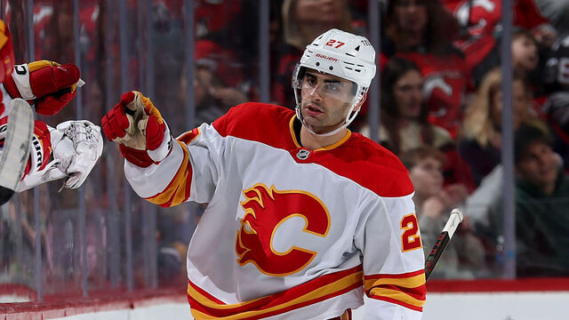 NEWARK, NEW JERSEY - MARCH 20: Matt Coronato #27 of the Calgary Flames celebrates his goal with teammates on the bench during the second period against the New Jersey Devils at Prudential Center on March 20, 2025 in Newark, New Jersey.