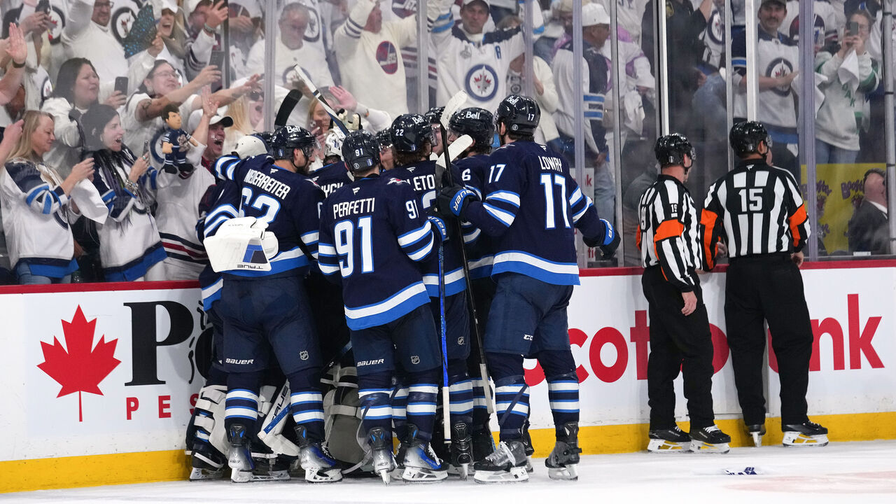 WINNIPEG, CANADA - MAY 04: Adam Lowry #17 of the Winnipeg Jets is congratulated by his teammates after scoring the game-winning goal against the St. Louis Blues in double overtime to win Game Seven of the First Round of the 2025 Stanley Cup Playoffs at Canada Life Centre on May 04, 2025 in Winnipeg, Manitoba, Canada.