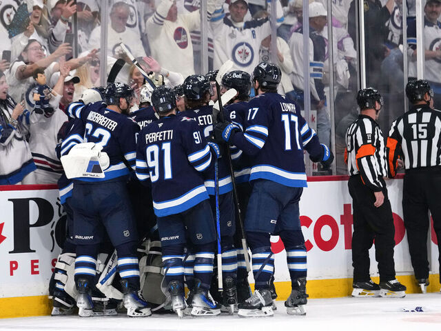 WINNIPEG, CANADA - MAY 04: Adam Lowry #17 of the Winnipeg Jets is congratulated by his teammates after scoring the game-winning goal against the St. Louis Blues in double overtime to win Game Seven of the First Round of the 2025 Stanley Cup Playoffs at Canada Life Centre on May 04, 2025 in Winnipeg, Manitoba, Canada.