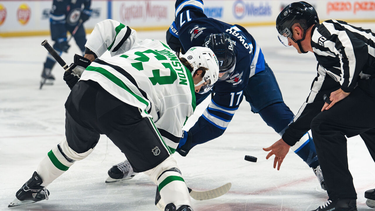 WINNIPEG, CANADA - MARCH 14: Wyatt Johnson #53 of the Dallas Stars and Adam Lowry #17 of the Winnipeg Jets face-off in the first period on at Canada Life Centre on March 14, 2025 in Winnipeg, Canada.