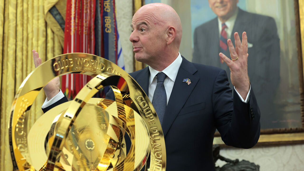 WASHINGTON, DC - MARCH 07: President of Fédération Internationale de Football Association (FIFA) Gianni Infantino (R) unveils the Club World Cup trophy alongside U.S. President Donald Trump in the Oval Office at the White House on March 07, 2025 in Washington, DC. President Trump signed an executive order establishing a White House Task Force for the 2026 World Cup.