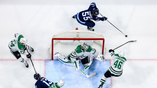 WINNIPEG, CANADA - MARCH 14: Goaltender Jake Oettinger #29 and Ilya Lyubushkin #46 of the Dallas Stars guard the net as Mark Scheifele #55 of the Winnipeg Jets plays the puck behind the goal during second period action at the Canada Life Centre on March 14, 2025 in Winnipeg, Manitoba, Canada.