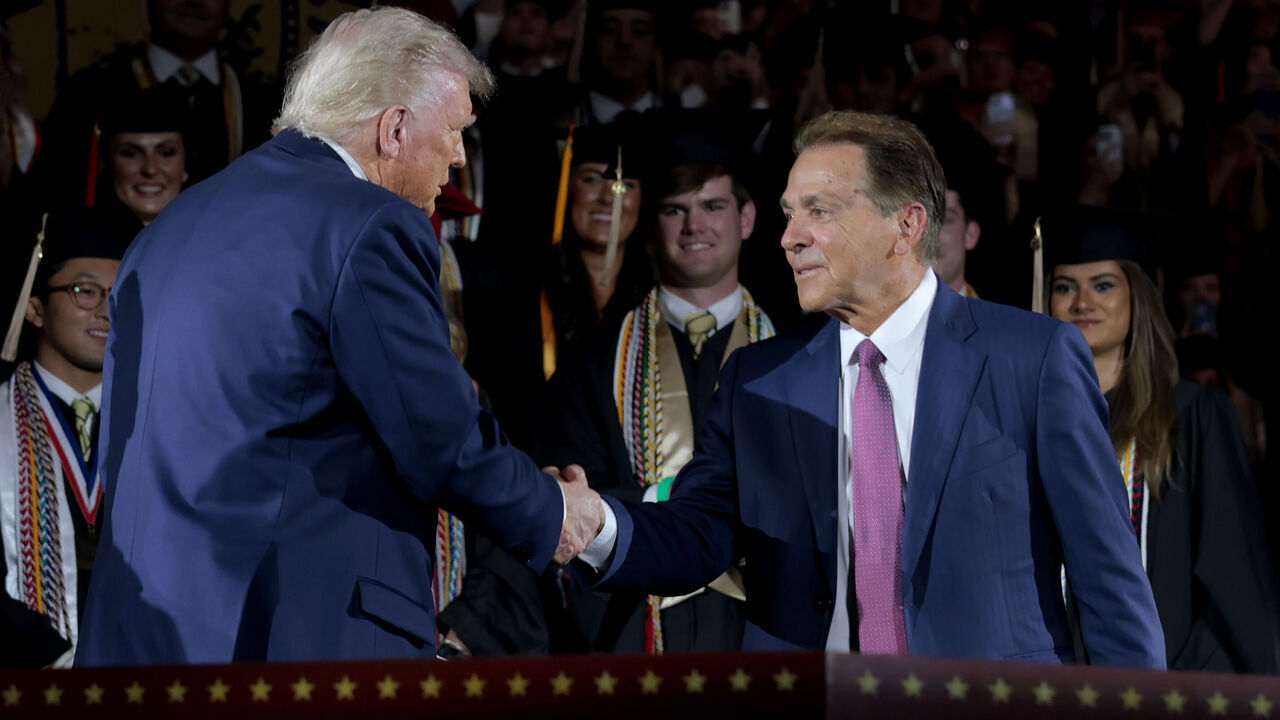 TUSCALOOSA, ALABAMA - MAY 01: U.S. President Donald Trump shakes hands with former Alabama Crimson Tide football coach Nick Saban as Trump takes the stage to address graduating students at Coleman Coliseum at the University of Alabama on May 01, 2025 in Tuscaloosa, Alabama. Trump's remarks come the day before commencement ceremonies.