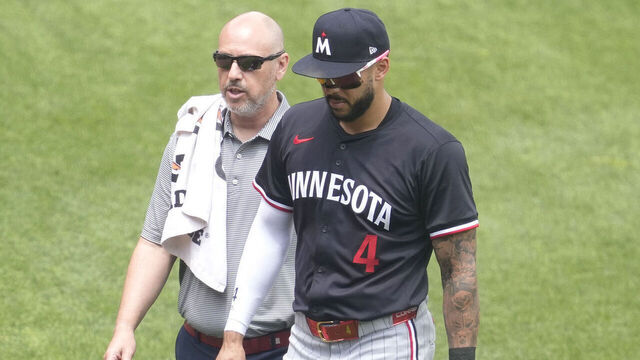 BALTIMORE, MD - MAY 15: Carlos Correa #4 of the Minnesota Twins is helped off field by head athletic trainer Nick Paparesta in the third inning after colliding with Byron Buxton #35 during a baseball game against the Minnesota Twins at Oriole Park at Camden Yards on May 15, 2025 in Baltimore, Maryland.