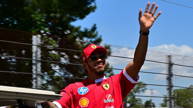 Ferrari's British driver Lewis Hamilton waves as he arrives on a golf cart before the 2025 Emilia Romagna Formula One Grand Prix at the Imola autodrome in Imola, on May 18, 2025.