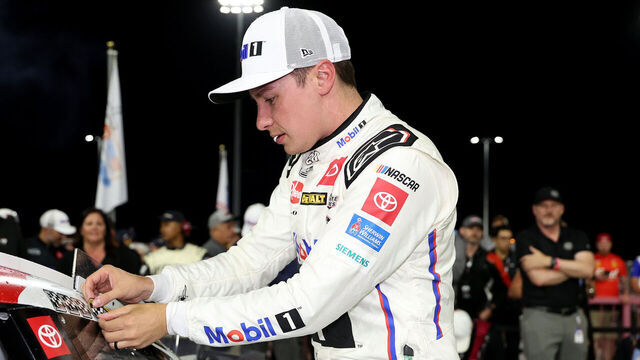 NORTH WILKESBORO, NORTH CAROLINA - MAY 18: Christopher Bell, driver of the #20 Mobil 1 Toyota, places the winner sticker on his car in victory lane after winning the NASCAR Cup Series All-Star Race at North Wilkesboro Speedway on May 18, 2025 in North Wilkesboro, North Carolina.