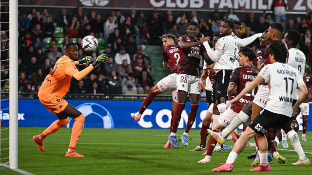 Metz's Senegalese goalkeeper #61 Pape Sy watches the ball as Reims' French defender #21 Cedric Kipre (C) scores Reims' first goal during the French L1 - L2 playoff first leg football match between FC Metz and Stade de Reims at the Saint-Symphorien Stadium in Metz, northeastern France, on May 21, 2025.