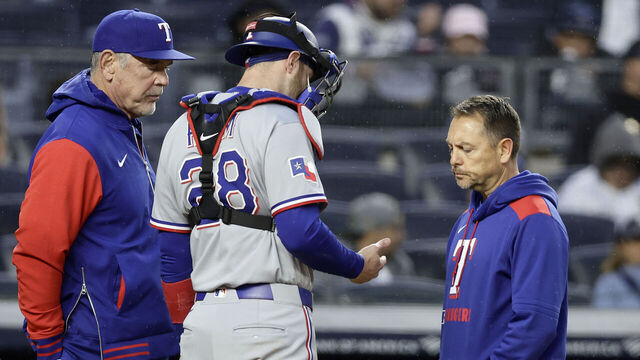 NEW YORK, NEW YORK - MAY 21: Jonah Heim #28 of the Texas Rangers is checked out by manager Bruce Bochy and a trainer before leaving a game during the second inning against the New York Yankees at Yankee Stadium on May 21, 2025 in New York City.