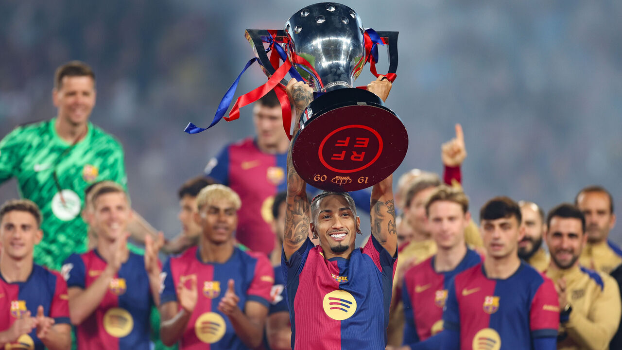BARCELONA, SPAIN - MAY 18: Raphinha of FC Barcelona lifts the La Liga EA Sports title trophy following the La Liga EA Sports match between FC Barcelona and Villarreal CF at Estadi Olimpic Lluis Companys on May 18, 2025 in Barcelona, Spain.