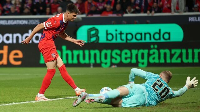 HEIDENHEIM, GERMANY - MAY 22: Mathias Honsak of Heidenheim shoots past Nicolas Kristof of Elvesberg to score his team's second goal during the Bundesliga playoffs first leg match between 1. FC Heidenheim 1846 and SV Elversberg at Voith-Arena on May 22, 2025 in Heidenheim, Germany.