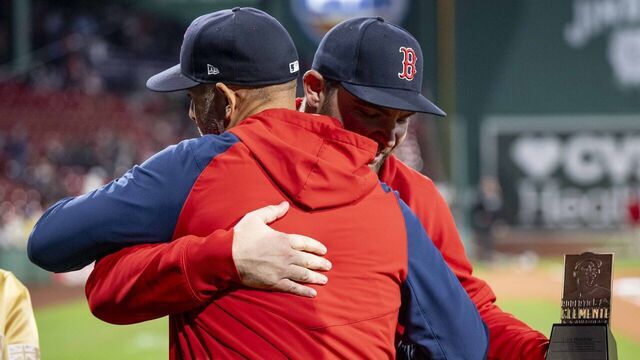 BOSTON, MA - SEPTEMBER 20: Liam Hendriks #31 of the Boston Red Sox is recognized as the Boston Red Sox Nominee for the 2024 Roberto Clemente Award and greeted by manager Alex Cora, Scott Dulin of the Roberto Clemente Foundation and his wife during a pre-game ceremony before a game against the Minnesota Twins on September 20, 2024 at Fenway Park in Boston, Massachusetts.