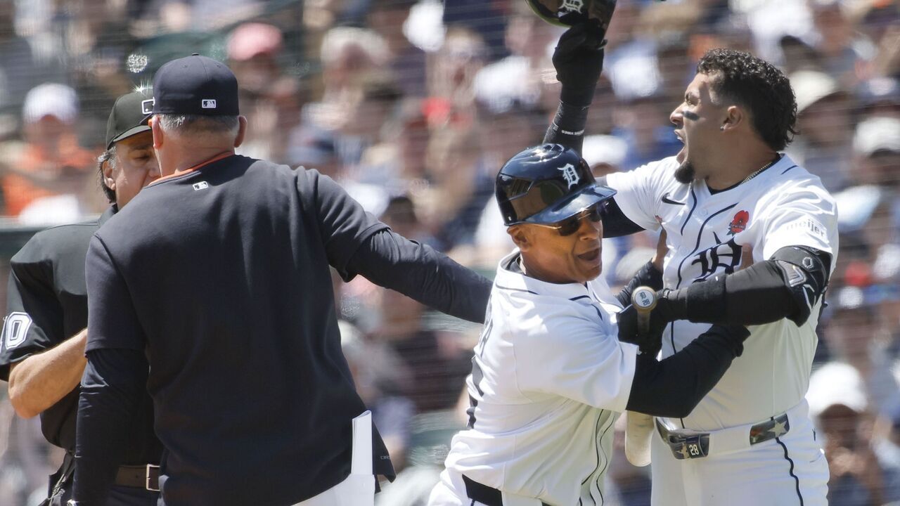 DETROIT, MI - MAY 26: Javier Baez #28 (R) of the Detroit Tigers is held back by third base coach Joey Cora #56 after being called out on strikes as manager manager A.J. Hinch #14 argues with home plate umpire Phil Cuzzi in the fifth inning at Comerica Park on May 26, 2025 in Detroit, Michigan.