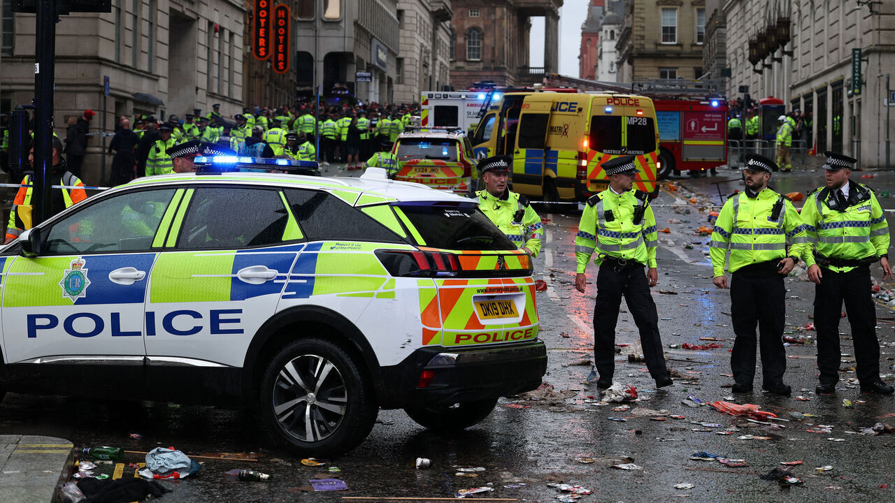 Police officers stand on duty at a cordon at the entrance to Water Street, at the scene of an incident, on the sidelines of an open-top bus victory parade for Liverpool's Premier League title win, in Liverpool, north-west England on May 26, 2025.