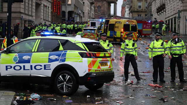 Police officers stand on duty at a cordon at the entrance to Water Street, at the scene of an incident, on the sidelines of an open-top bus victory parade for Liverpool's Premier League title win, in Liverpool, north-west England on May 26, 2025.