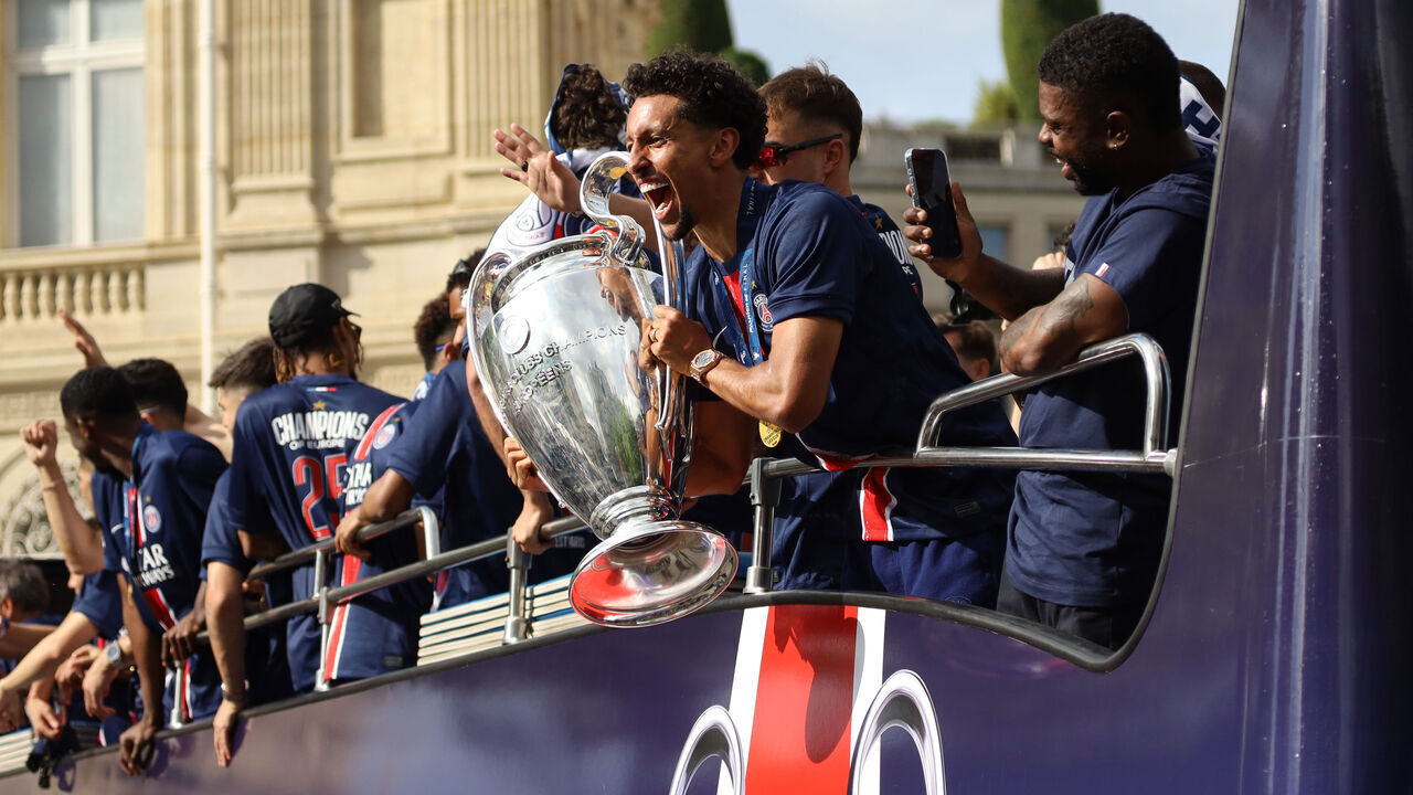 PARIS, FRANCE - JUNE 01: PSG football players carry the UCL trophy on the bus as football fans celebrate Paris Saint-Germain's (PSG) UEFA Champions League title at Champs-Elysees in Paris, France on June 01, 2025. PSG defeated the Italy Milan 5-0 to win the Champions League last night.