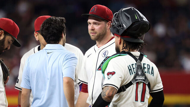 PHOENIX, ARIZONA - JUNE 01: Starting pitcher Corbin Burnes #39 of the Arizona Diamondbacks talks with with assistant athletic trainer Max Esposito before being removed from the game during the fifth inning against the Washington Nationals at Chase Field on June 01, 2025 in Phoenix, Arizona.