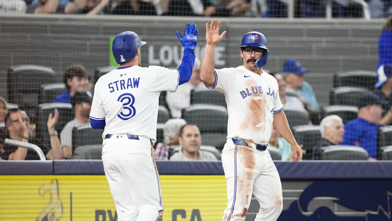 TORONTO, ON - JUNE 5: Myles Straw #3 and Davis Schneider #36 of the Toronto Blue Jays celebrate scoring against the Philadelphia Phillies during the third inningin their MLB game at the Rogers Centre on June 5, 2025 in Toronto, Ontario, Canada.