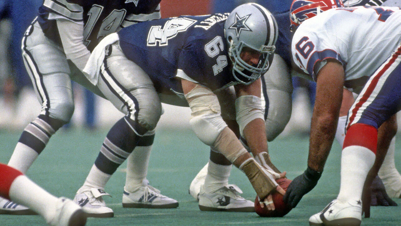 ORCHARD PARK, NY - NOVEMBER 18: Quarterback Gary Hogeboom #14 of the Dallas Cowboys stands behind center Tom Rafferty #64 during a game against the Buffalo Bills at Rich Stadium on November 18, 1984 in Orchard Park, New York. The Bills defeated the Cowboys 14-3.