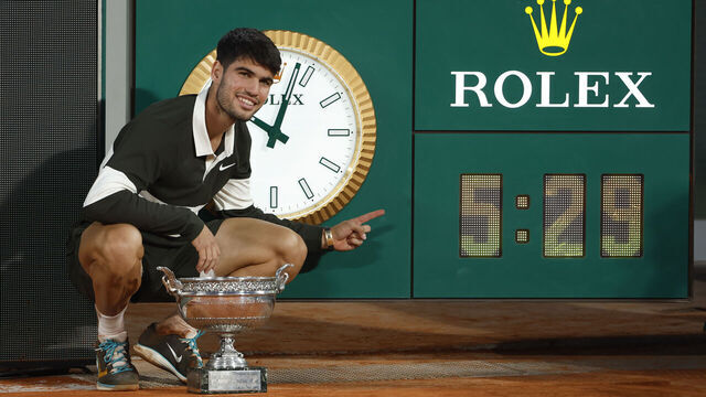 PARIS, FRANCE - JUNE 9: Winner Carlos Alcaraz of Spain poses next to the Rolex clock after the longest men's final in Roland-Garros (5h29) on day 15 of the 2025 French Open, Roland-Garros 2025, Grand Slam tennis tournament at Roland Garros stadium on June 8, 2025 in Paris, France.