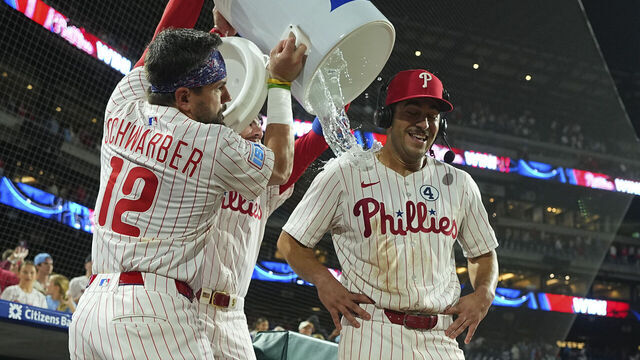 PHILADELPHIA, PENNSYLVANIA - JUNE 9: Kyle Schwarber #12 and Bryson Stott #5 of the Philadelphia Phillies pour water on Otto Kemp #4 after the game against the Chicago Cubs at Citizens Bank Park on June 9, 2025 in Philadelphia, Pennsylvania. The Phillies defeated the Cubs 4-3 in extra innings.